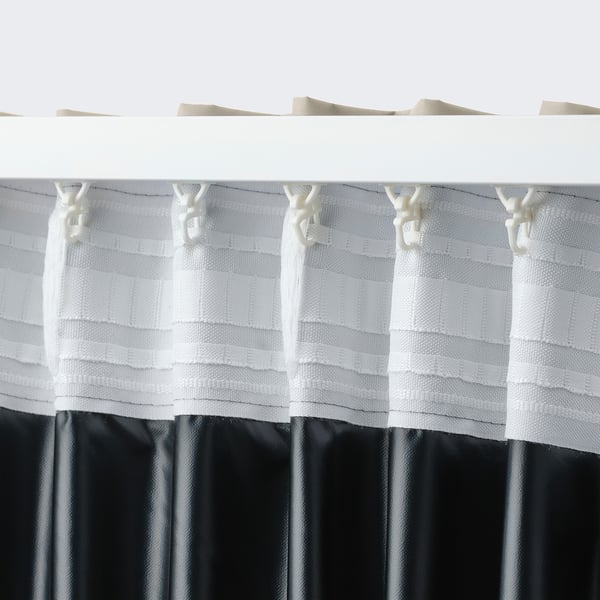 Rideaux blancs avec crochets suspendus, avec ruban de tête beige, montrant le blocage de la lumière et l’intimité.