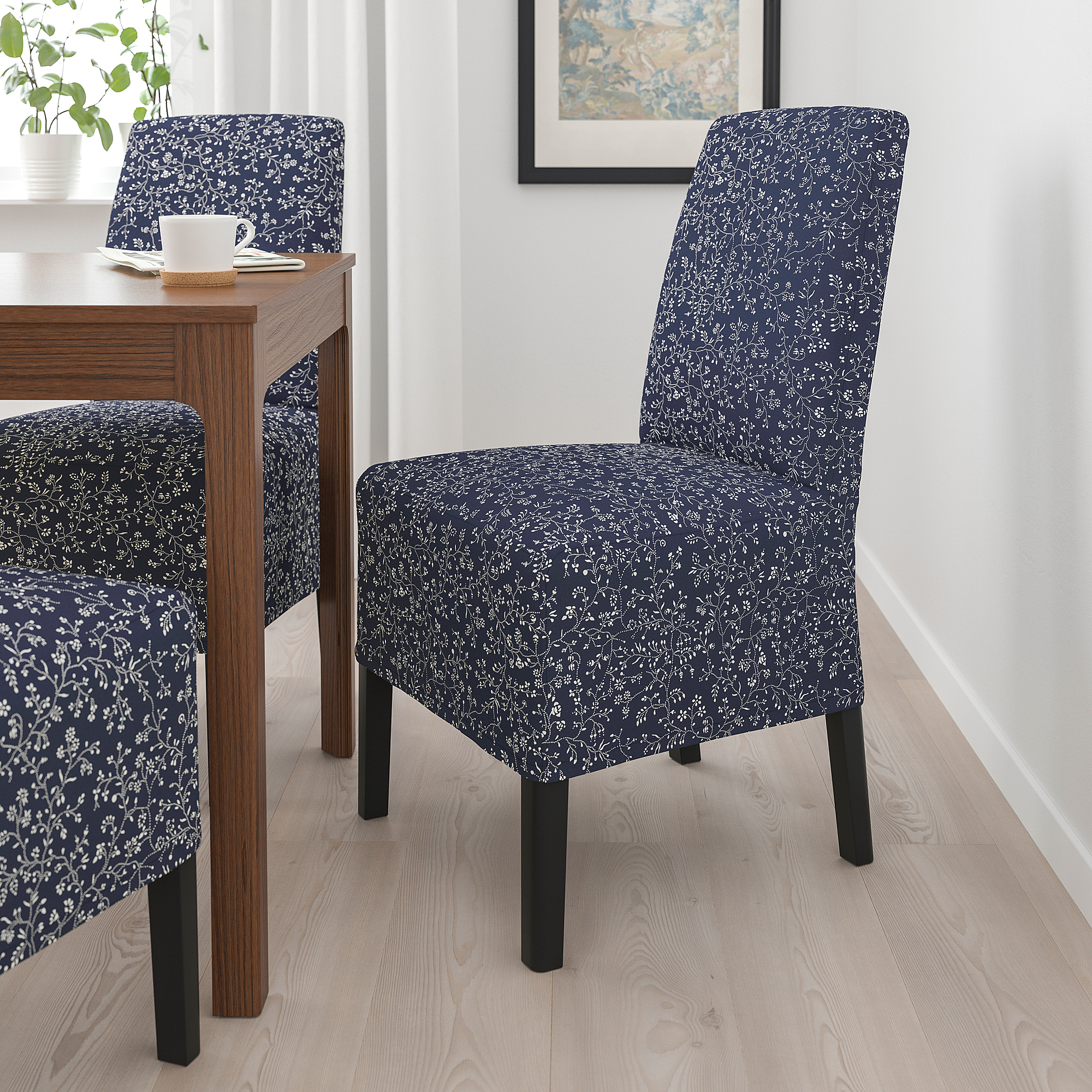 Chaise BERGMUND florale bleu foncé avec assise rembourrée et pieds en bois noir.