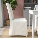 Chaise rembourrée blanche avec dossier haut et pieds en bois massif, idéale pour une assise confortable.