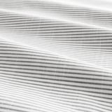 Gros plan d’un tissu en coton à rayures, mettant en valeur sa texture douce et ses rayures teintes en fil.