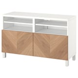 Un banc tv BESTÅ en blanc avec des portes en bois. Il dispose de deux étagères ouvertes et de deux armoires avec charnières à fermeture douce.