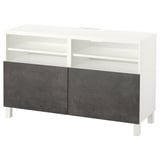 Un banc TV BESTÅ blanc et gris avec des étagères ouvertes et des compartiments réglables pour la gestion des câbles.