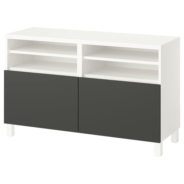 Un banc TV BESTÅ blanc avec des portes gris foncé. Il dispose d’étagères ouvertes et d’un design moderne.