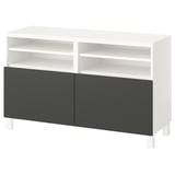 Un banc TV BESTÅ blanc avec des portes gris foncé. Il dispose d’étagères ouvertes et d’un design moderne.