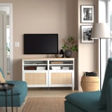 Banc TV BESTÅ blanc avec écran plat, chaises turquoise, photos, lampe, panier.