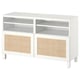 Un banc TV BESTÅ blanc avec des portes tressées et des étagères ouvertes. Il combine un design moderne avec un rangement pratique.