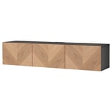 Le banc TV BESTÅ en bois brun clair et noir, rectangulaire avec trois portes battantes, conçu pour le rangement et la gestion des câbles.