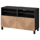 Banc TV BESTÅ, noir avec portes en bois, forme rectangulaire, rangement et gestion des câbles.