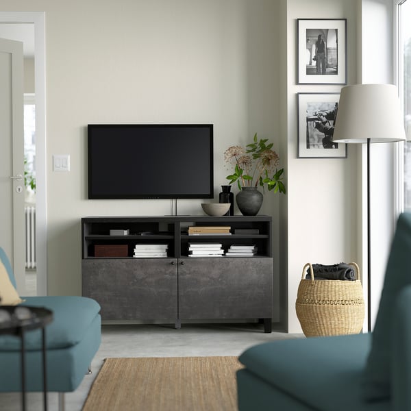 Salon moderne avec meuble TV BESTÅ, télévision à écran plat, canapé turquoise et lampadaire. Décor minimaliste, lumière naturelle.