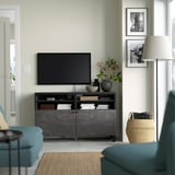 Salon moderne avec meuble TV BESTÅ, télévision à écran plat, canapé turquoise et lampadaire. Décor minimaliste, lumière naturelle.