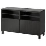 Meuble TV BESTÅ noir : design élégant, rectangulaire et moderne avec quatre étagères réglables, deux portes d’armoire et un système de gestion des câbles.