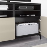 Meuble TV BESTÅ noir avec gestion des câbles dissimulée, charnières à fermeture douce et compartiments de rangement.