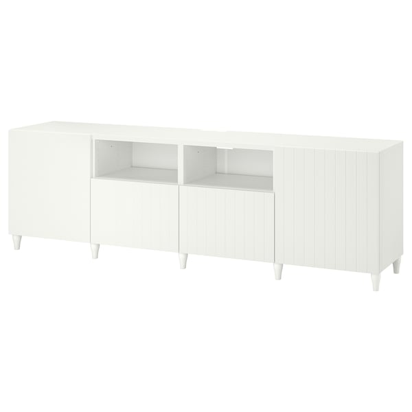 Le meuble TV BESTÅ blanc combine rangement et gestion des câbles, design élégant avec des pieds en bois.