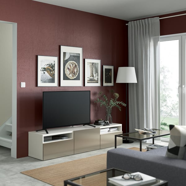 Salon moderne avec banc TV BESTÅ, télévision à écran plat, art de l’art, canapé gris, table en verre et lampadaire.