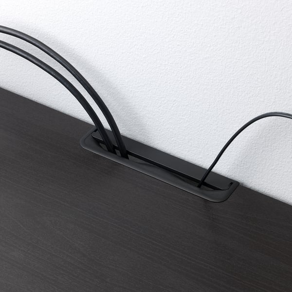 Banc TV noir avec pieds réglables et sorties de câbles, assurant la stabilité et le câblage organisé.