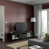 Salon moderne avec murs marron, banc TV BESTÅ, lampe, table basse et grande fenêtre.