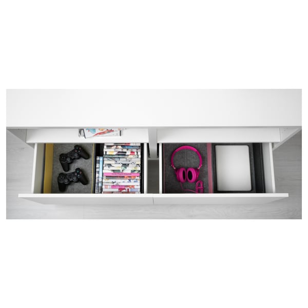 Organisateur de tiroir blanc avec des manettes de jeu, des livres, des écouteurs et un ordinateur portable.