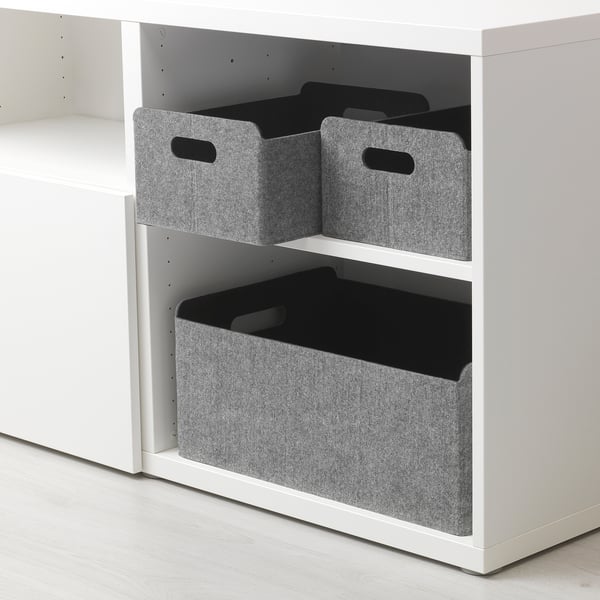 Trois boîtes de rangement en feutre sur une étagère blanche, deux empilées, une en dessous.