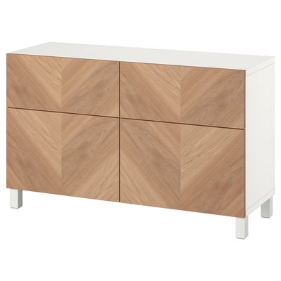 Un buffet BESTÅ en bois blanc et naturel, composé de quatre portes et de tiroirs en placage de chêne à motif chevron.