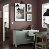 Salon moderne avec murs rouges, buffet BESTÅ blanc, suspensions et décoration.