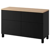 Un buffet BESTÅ noir et bois avec quatre compartiments et des pieds noirs. Il s’agit d’un design élégant et moderne pour le rangement.