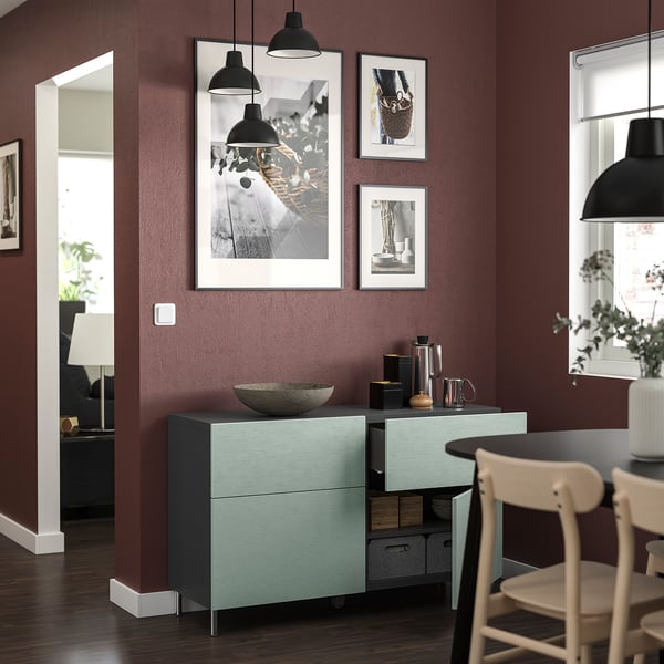 Salon moderne avec buffet BESTÅ bleu, mur marron, objets décoratifs, photos encadrées et suspension noire.