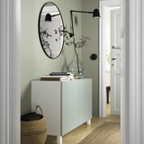 BESTÅ vert moderne avec miroir, lampes et couvertures.
