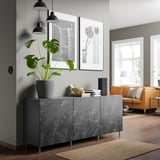 Salon moderne avec buffet BESTÅ en marbre gris, avec une grande plante, des photos encadrées et un canapé orange.