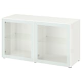 Une armoire blanche ikea BESTÅ avec des portes et des étagères en verre. Il a une forme rectangulaire et un design minimaliste.
