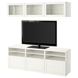 Meuble TV blanc avec armoires et portes vitrées, tenant un téléviseur noir, conçu pour organiser l’électronique et l’affichage.