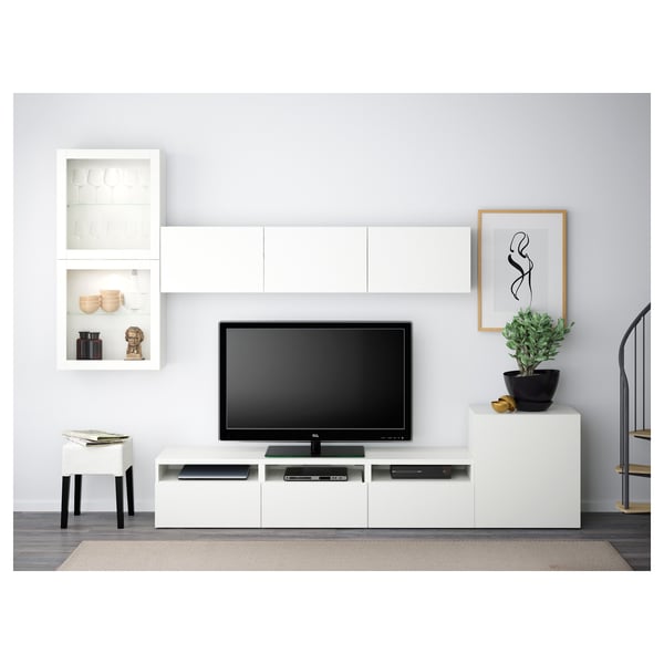 Salon moderne avec meuble TV BESTÅ blanc, télévision à écran plat, armoires murales et plante ; Idéal pour un espace organisé et sans encombrement.
