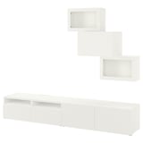Un meuble de rangement TV BESTÅ blanc. Il comprend une large armoire, deux armoires murales et des étagères. Les armoires sont élégantes et modernes, offrant un grand espace de rangement.
