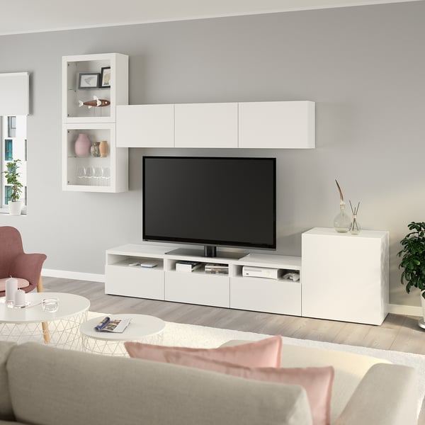 Salon moderne avec meuble TV BESTÅ, écran plat, canapé confortable, oreillers roses, parquet.