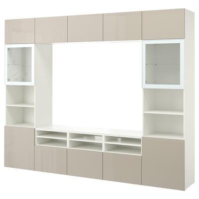 Une unité de rangement pour téléviseur BESTÅ blanc cassé avec diverses étagères et armoires pour un rangement organisé, avec des sections ouvertes et fermées.