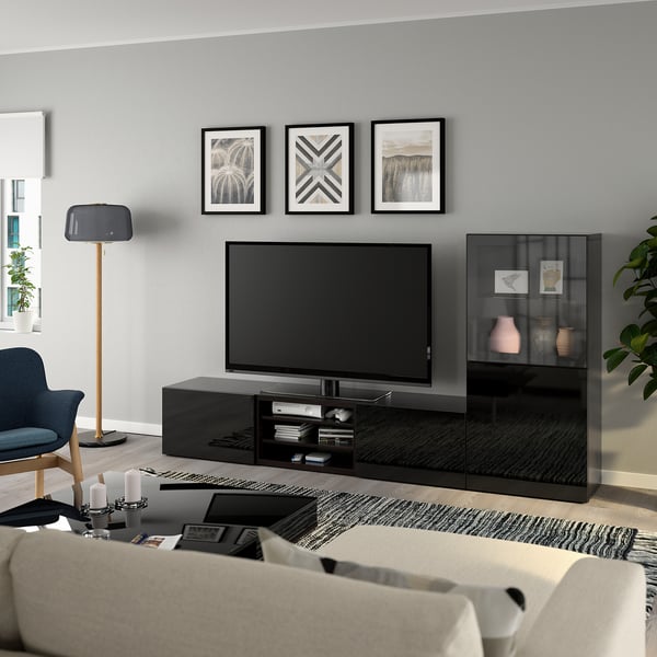 Salon moderne avec meuble tv BESTÅ, chaise grise et bougies. Art en noir et blanc au-dessus de la télévision. Confortable et minimaliste.