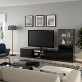 Salon moderne avec meuble tv BESTÅ, chaise grise et bougies. Art en noir et blanc au-dessus de la télévision. Confortable et minimaliste.