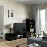 Salon moderne avec meuble TV BESTÅ, étagères, lampe et rangement.