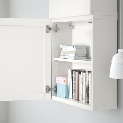 Armoire blanche ouverte avec deux étagères, contenant des piles de livres et de boîtes. Solution de rangement ajustable et personnalisable.