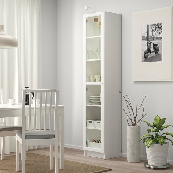 Étagère BILLY blanche avec de la vaisselle et des plantes dans une salle à manger minimaliste.