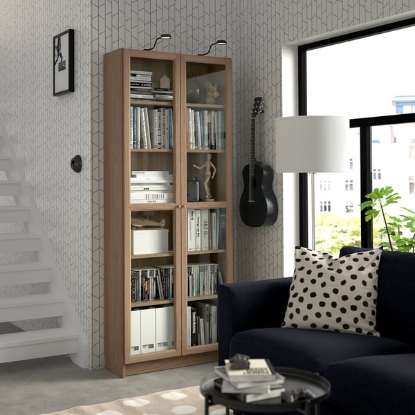 Salon avec bibliothèque BLY, guitare et coussin à pois.