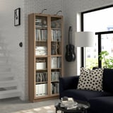 Salon avec bibliothèque BLY, guitare et coussin à pois.
