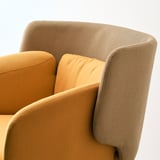Gros plan du fauteuil BINGSTA mettant en valeur son dossier incurvé en tissu jaune bicolore, mettant en valeur son design confortable et élégant.