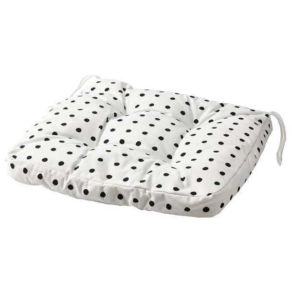 Un coussin BJÖRKTRAST à pois noirs sur fond blanc. Il est de forme carrée avec des liens à chaque coin pour un placement sûr.