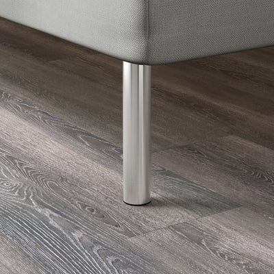 Pied de table moderne en métal avec assise rembourrée sur plancher en bois.