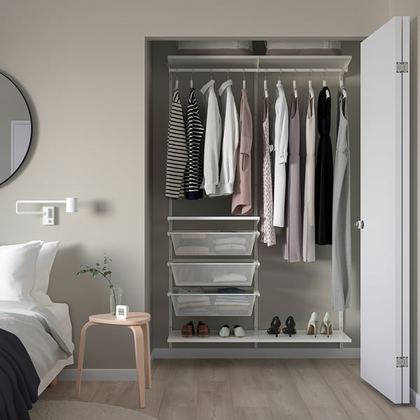 Placard ouvert avec organisation des vêtements et des chaussures. Design moderne, couleurs blanches et grises. Tiroirs en maille et barres de suspension. Étagère à chaussures en bas.