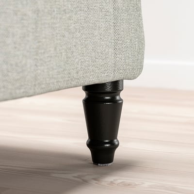 Un cadre de lit rembourré gris clair avec des pieds en bois foncé, offrant un design traditionnel et un soutien solide.