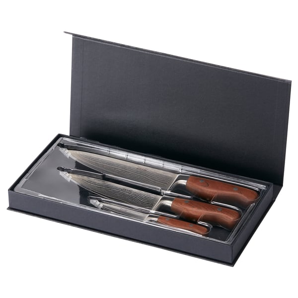 Un set de couteaux BRILJERA dans sa mallette. Poignées en acier inoxydable et en bois. Lames en damasteel. Noir et design épuré.