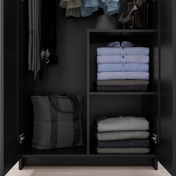 Armoire BRIMNES noire avec vêtements et sac fourre-tout.