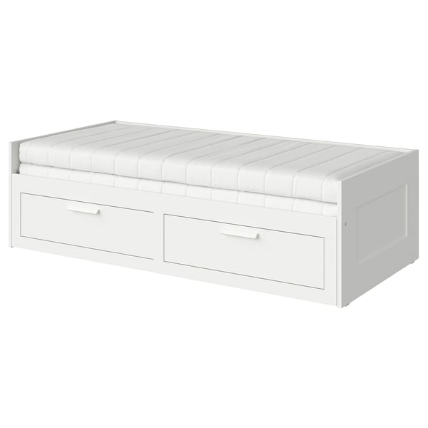 Cette image montre un lit de repos BRIMNES blanc avec deux tiroirs de rangement et un matelas en mousse. Il se transforme de canapé en lit, idéal pour les petits espaces.