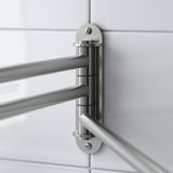 Sèche-serviettes en acier inoxydable avec bras réglables monté sur un mur carrelé.